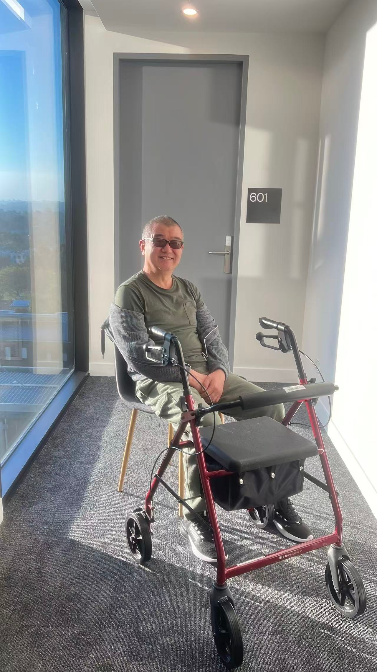 Access Life participant smiling in hallway with mobility aid